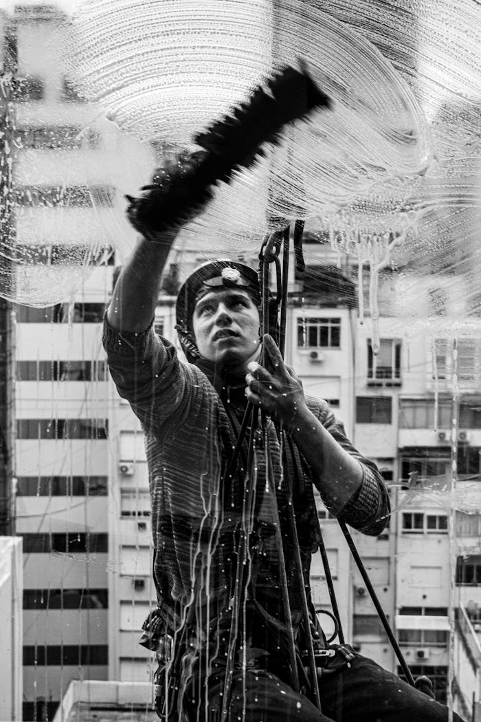 A black and white action shot of a window cleaner working in Buenos Aires, Argentina.